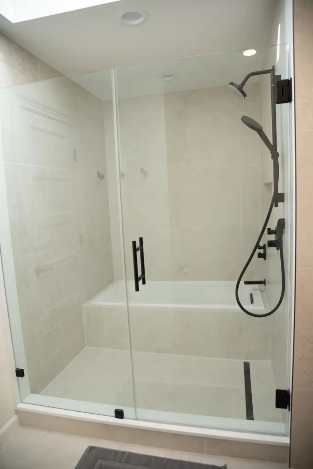 Glass enclosure over a tiled tub and shower
