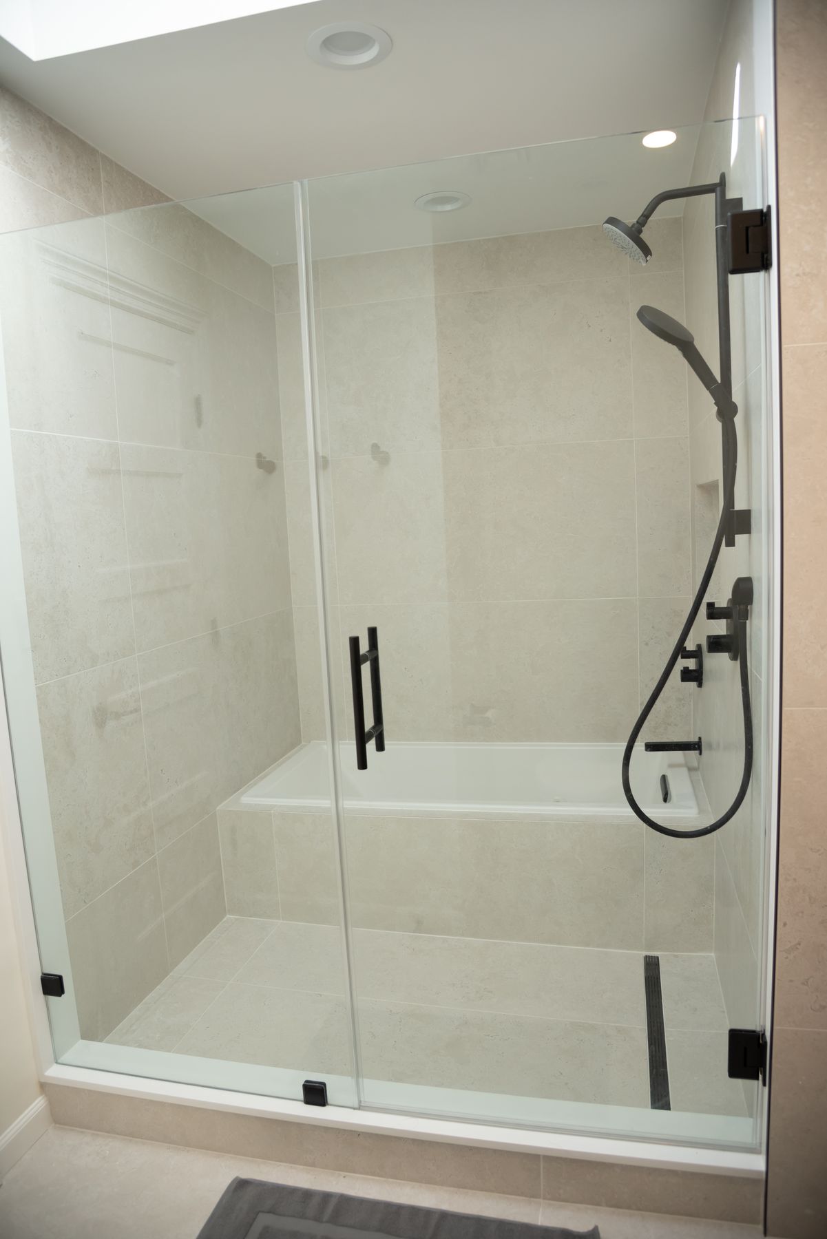 Glass enclosure over a tiled tub and shower