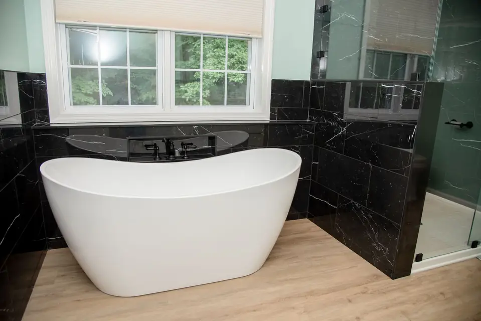 Freestanding soaking tub beside a glass shower