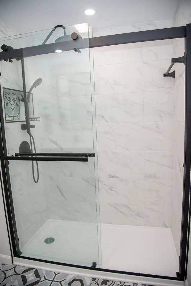 Marble tile walk-in shower with sliding glass doors