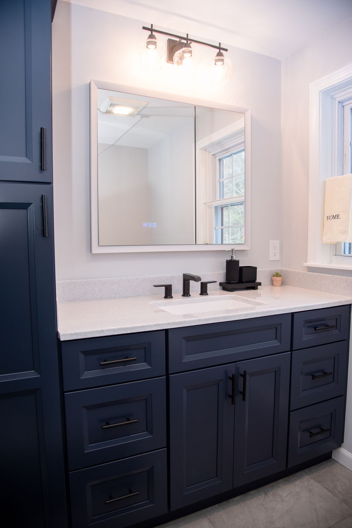 Navy vanity with quartz top and black fixtures